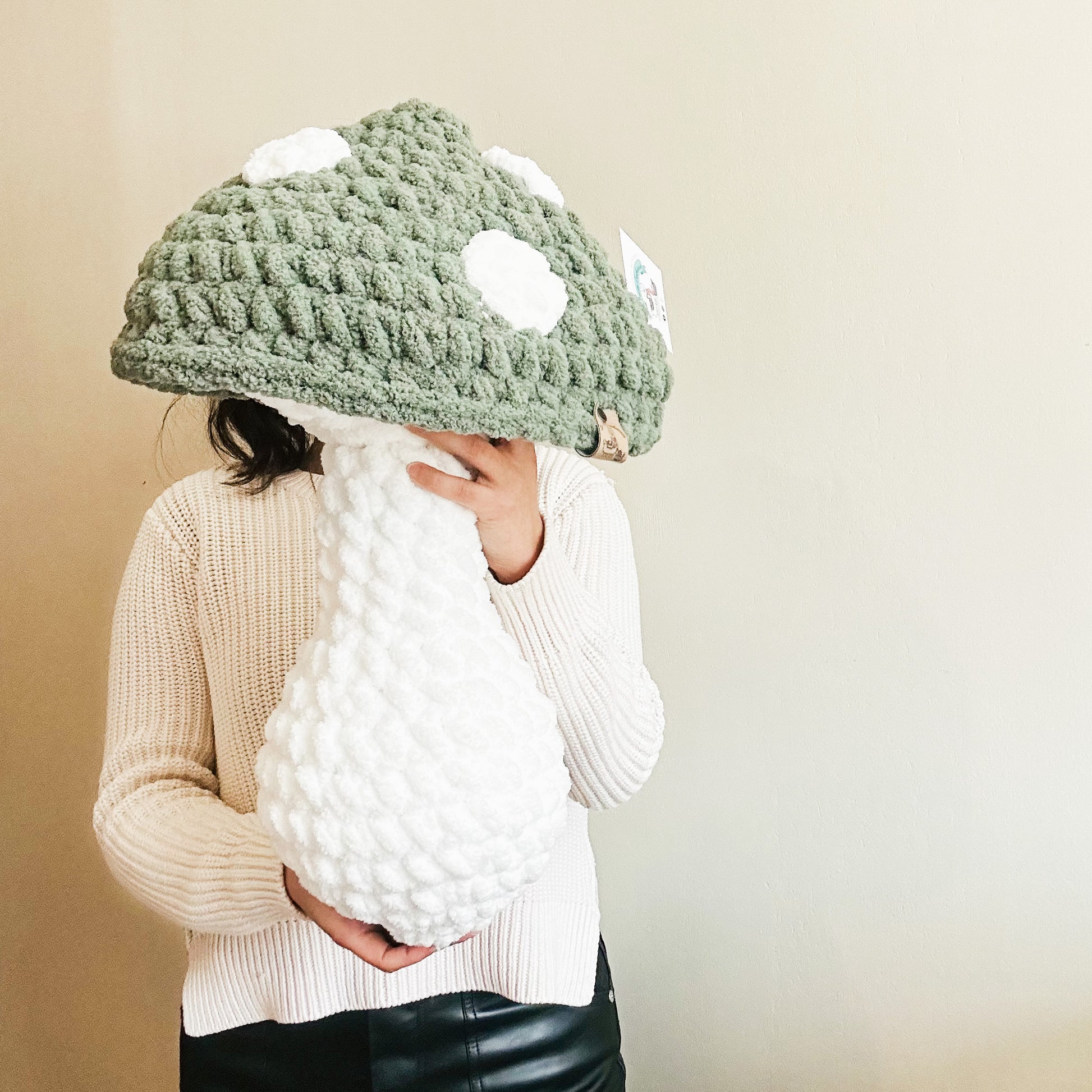 Green mushroom pillow with white spots on the cap