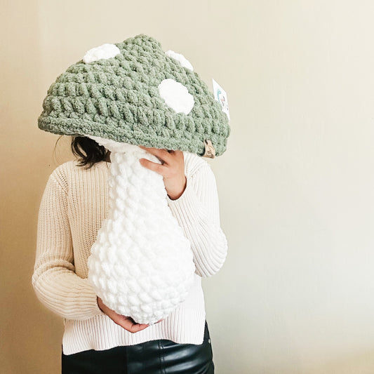 Green mushroom pillow with white spots on the cap
