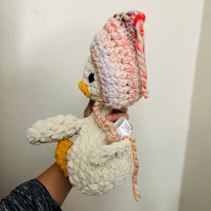 crochet duck snuggler with pink and purple beanie side view
