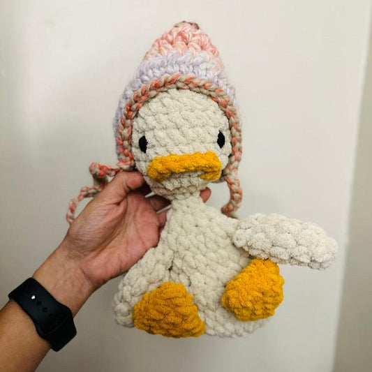 crochet duck snuggler with pink and purple beanie
