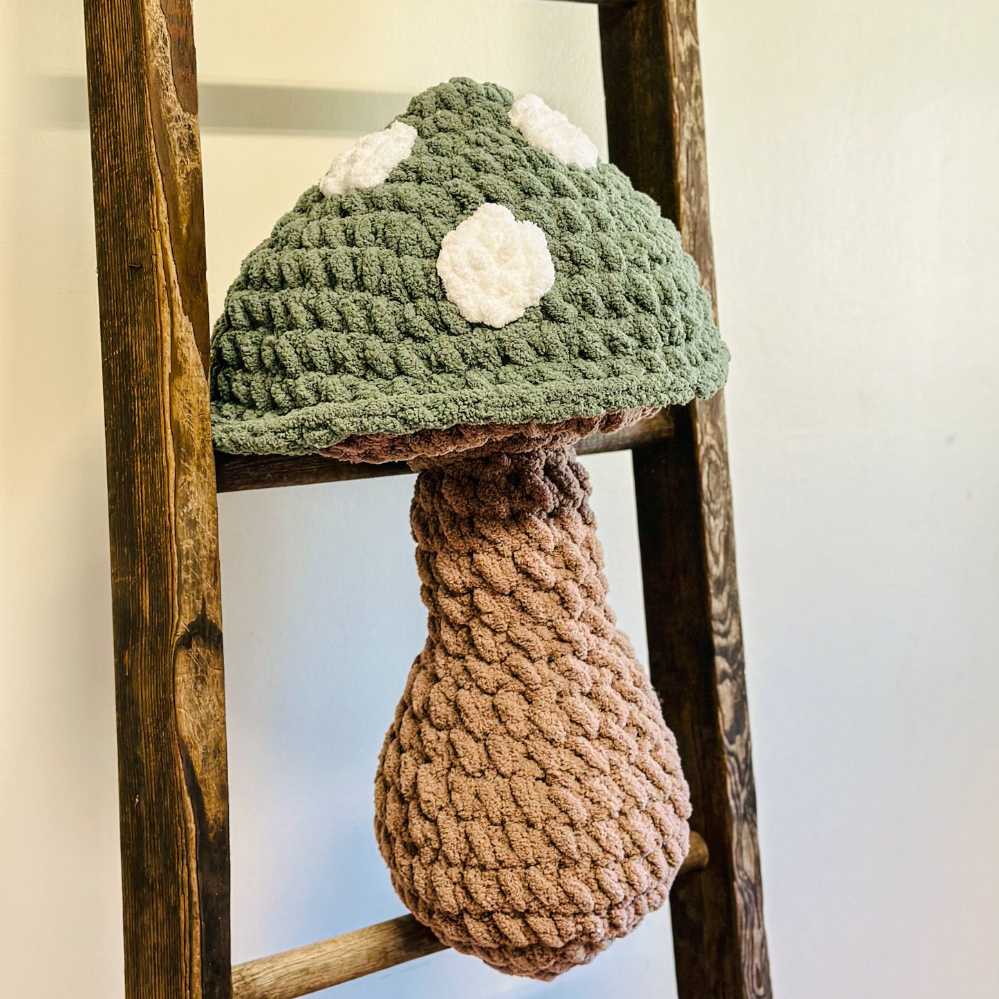 green mushroom cap with white spots and brown stem on a ladder