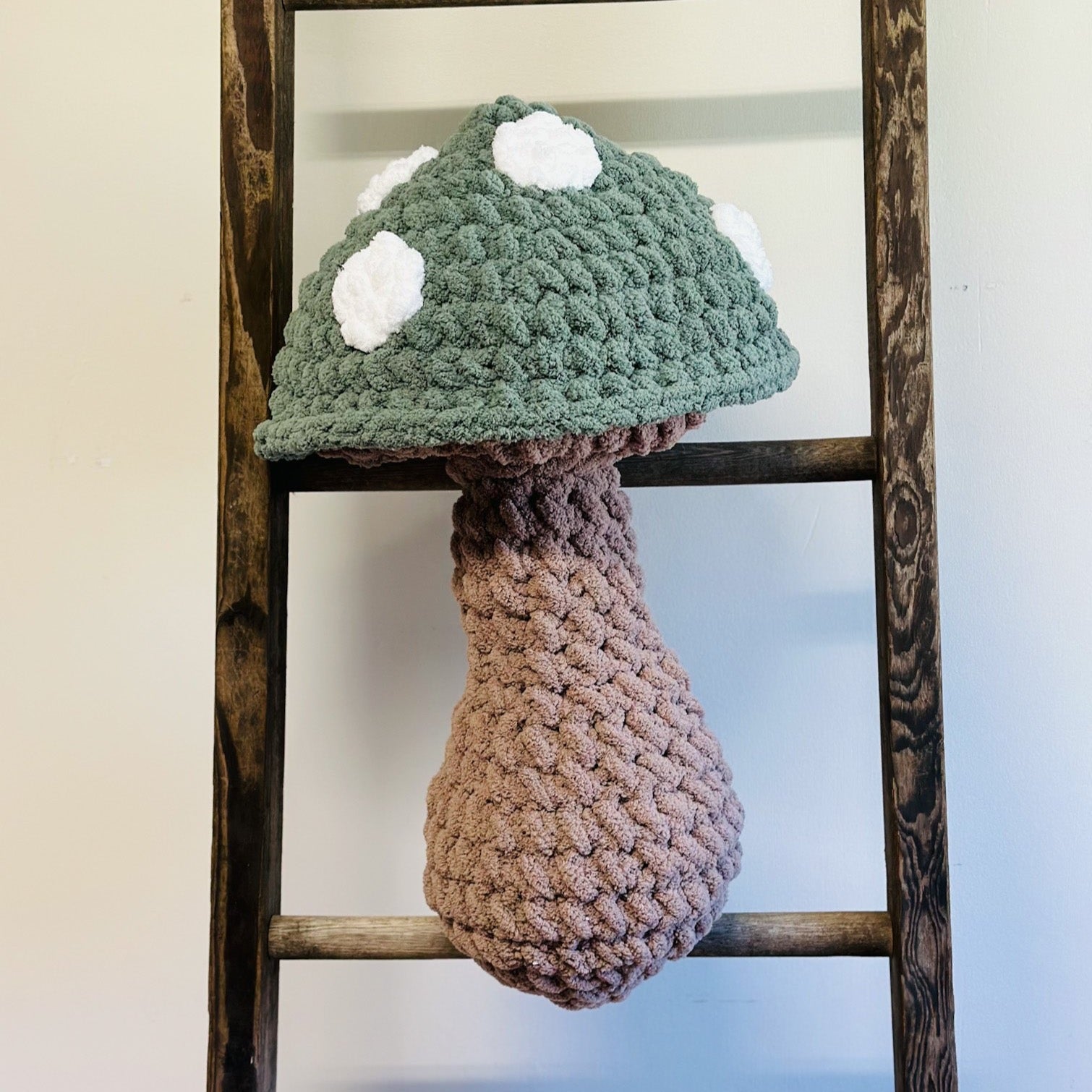 green and brown mushroom pillow on a ladder